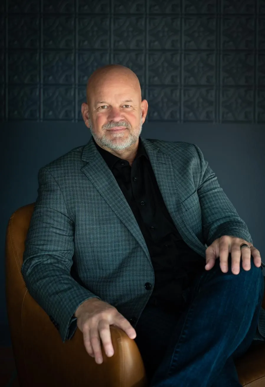 Troy Murphy seated in a leather chair, wearing a plaid jacket